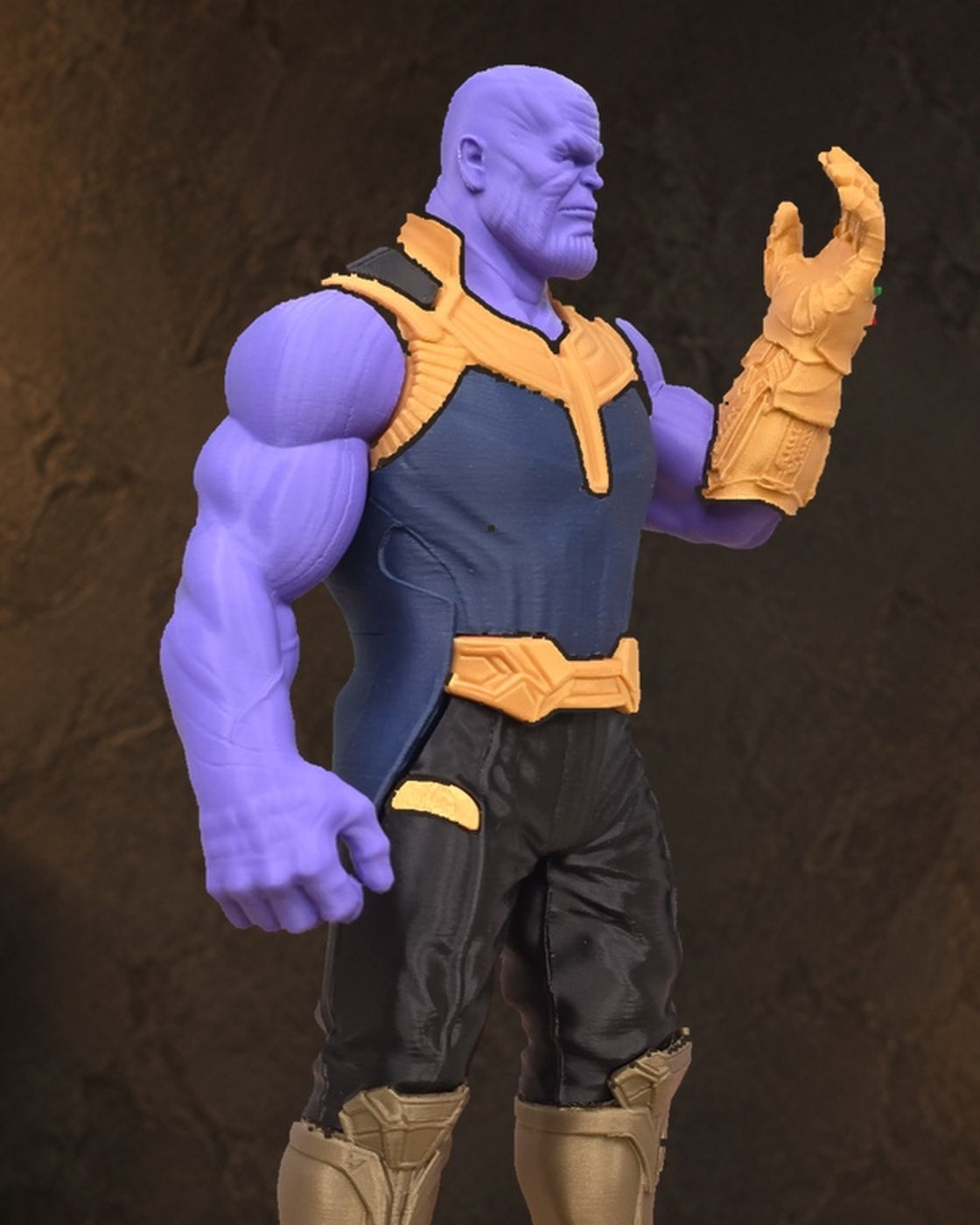 Pormenor do rosto, armadura e manopla do Thanos num ambiente de exposição